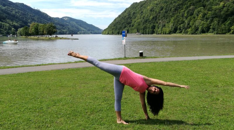 Dunkelhaarige Frau macht Yoga direkt an der Donau