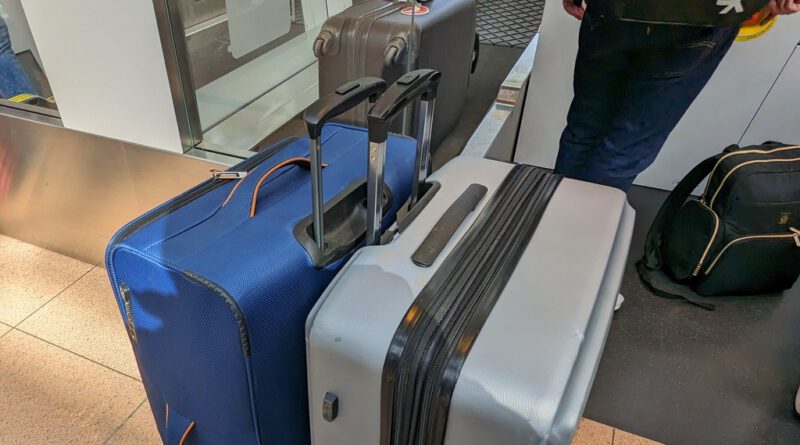 Drei Koffer an der Geöpäckaufgabe eines Flugplatzes